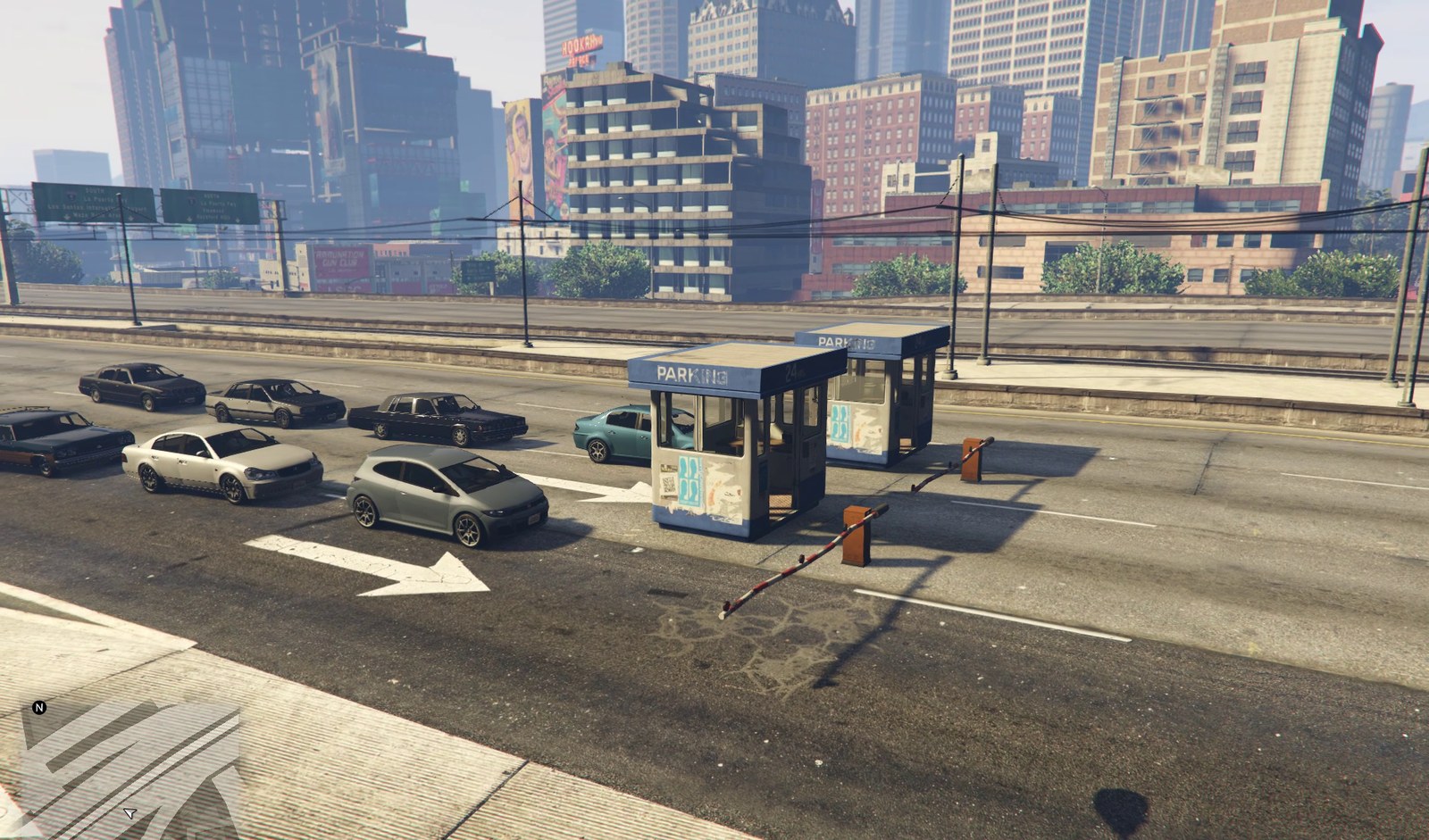 A three-lane toll plaza across an elevated freeway through downtown Los Santos: kiosks on the islands between the lanes, barrier arms across two of them, and traffic waiting.
